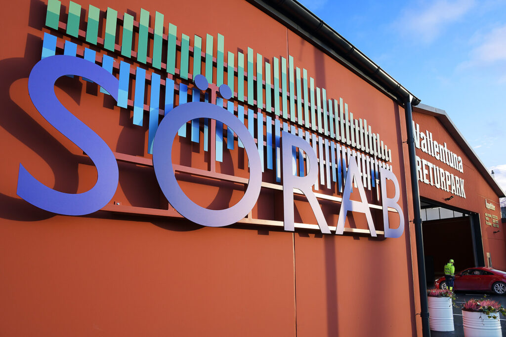 Entrén till Vallentuna Returpark med en stor SÖRAB-logga på väggen
